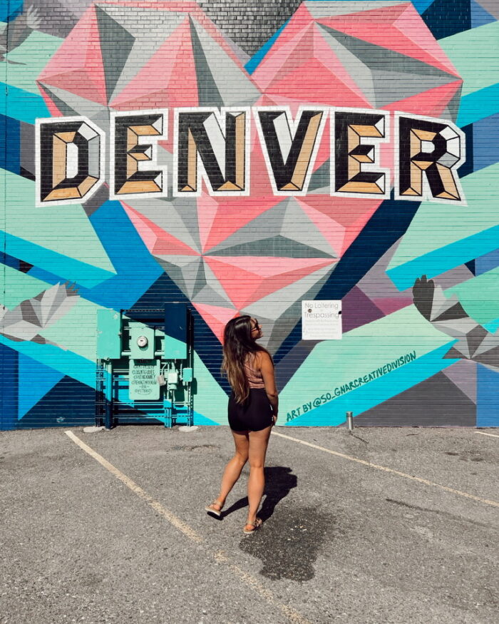 Raquel in front of a DENVER mural