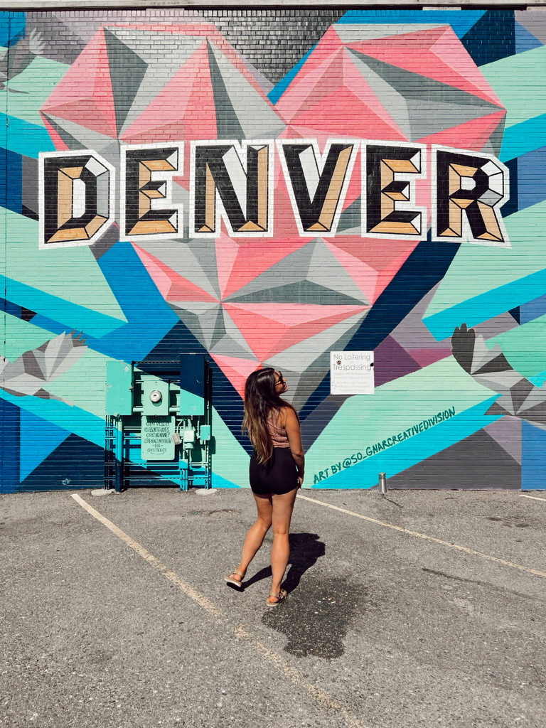 Raquel in front of a DENVER mural
